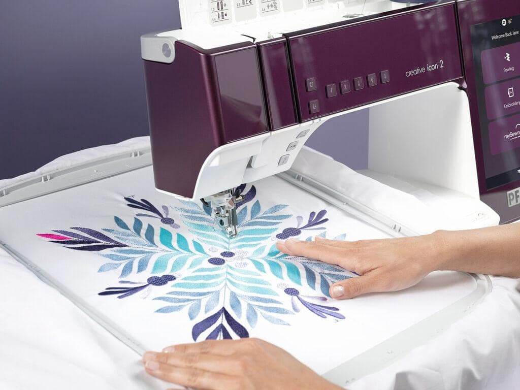 Stickmaschine stickt ein Motiv im Stickrahmen